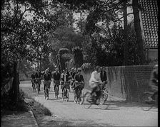 A Group of Young Female Civilians Wearing School Uniforms Riding Bicycles Along a Dusty Road, 1920. Creator: British Pathe Ltd