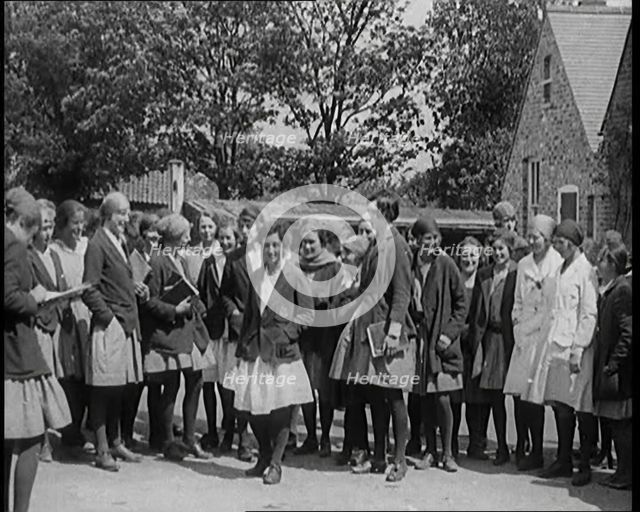 A Group of Young Female Civilians Wearing School Uniforms Standing in Front of a School, 1920. Creator: British Pathe Ltd.