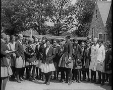 A Group of Young Female Civilians Wearing School Uniforms Standing in Front of a School, 1920. Creator: British Pathe Ltd