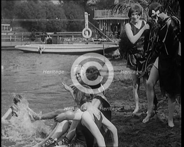 A Group of Young Female Civilians Wearing Swimsuits Playing on Riverside, 1920. Creator: British Pathe Ltd.