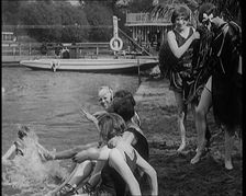 A Group of Young Female Civilians Wearing Swimsuits Playing on Riverside, 1920. Creator: British Pathe Ltd