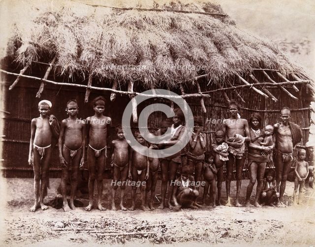 A group of adults and children standing in a line outside a bamboo hut with a thatched..., 1896/1897 Creator: Unknown.
