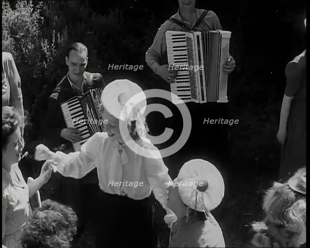 A Group of British Girls Dancing As Two British Men Play Accordion Music, 1938. Creator: British Pathe Ltd.