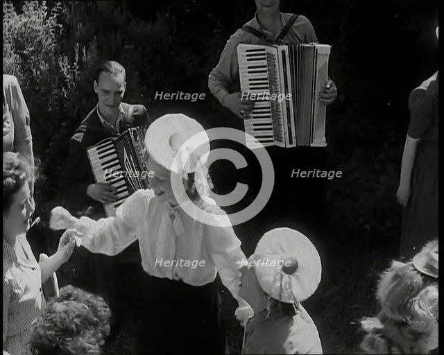 A Group of British Girls Dancing As Two British Men Play Accordion Music, 1938. Creator: British Pathe Ltd.