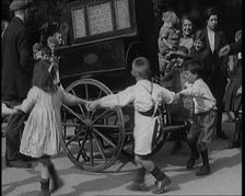A Group of Civilian Children Dancing Around a Hurdy Gurdy, 1920. Creator: British Pathe Ltd