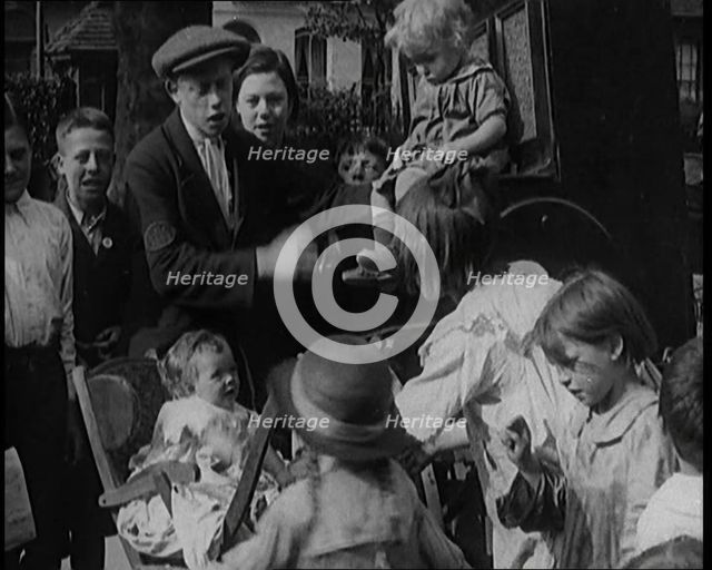 A Group of Civilian Children Dancing in Front of a Hurdy Gurdy Watched by a Small Crowd..., 1920. Creator: British Pathe Ltd.