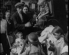 A Group of Civilian Children Dancing in Front of a Hurdy Gurdy Watched by a Small Crowd..., 1920. Creator: British Pathe Ltd