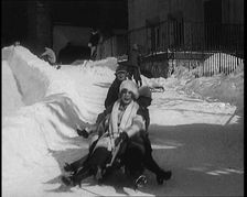 A Group of Civilians Having Fun Sledging down a Snowy Hill, 1920. Creator: British Pathe Ltd
