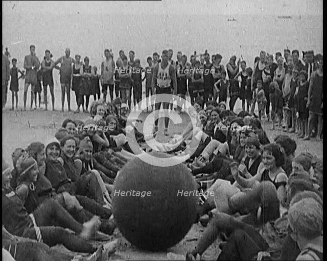 A Group of Female Civilians Exercising with a Large Ball on a Beach, 1920. Creator: British Pathe Ltd.