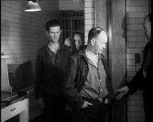 A group of Male Americans Civilians Wearing Prisoners Outfits Being Escorted Into a Room..., 1930. Creator: British Pathe Ltd
