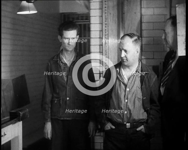 A group of Male Americans Civilians Wearing Prisoners Outfits Being Escorted Into a Room..., 1930. Creator: British Pathe Ltd.