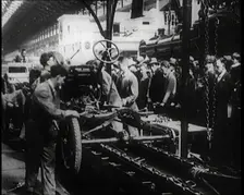 A Group of Male Civilians Building a Car As a Crowd of People Watch. Behind the Crowd..., 1924. Creator: British Pathe Ltd