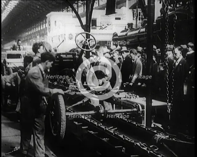 A Group of Male Civilians Building a Car As a Crowd of People Watch. Behind the Crowd..., 1924. Creator: British Pathe Ltd.