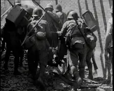 A Group of Male Japanese Soldiers Pushing a Gun Over Rubble in a Street in Shanghai, 1937. Creator: British Pathe Ltd