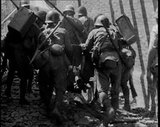 A Group of Male Japanese Soldiers Pushing a Gun Over Rubble in a Street in Shanghai, 1937. Creator: British Pathe Ltd