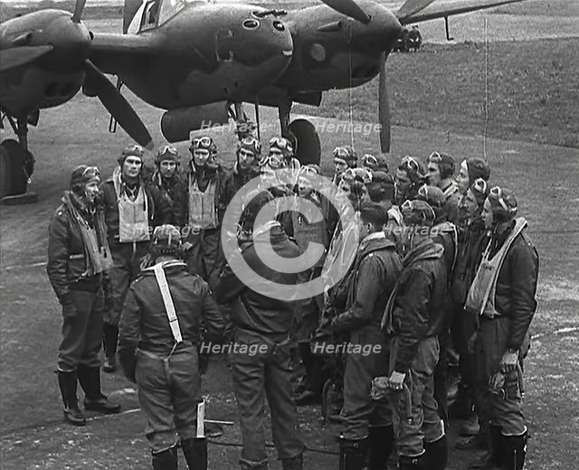 A Group of Male Pilots Talking in Front of an Aircraft, 1943-1944. Creator: British Pathe Ltd.