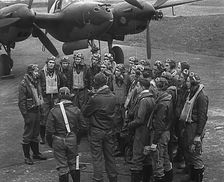 A Group of Male Pilots Talking in Front of an Aircraft, 1943-1944. Creator: British Pathe Ltd