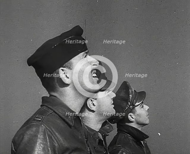 A Group of Male Pilots Watching Aircraft in the Sky, 1943-1944. Creator: British Pathe Ltd.