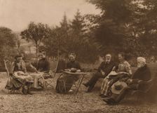A group of men and women sat talking by a table 1937. Artist: Louis Guichard