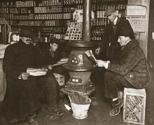 A group of men around a stove in a shop, USA, c1910