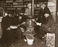 A group of men around a stove in a shop, USA, c1910. Creator: Unknown