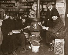 A group of men around a stove in a shop, USA, c1910. Creator: Unknown