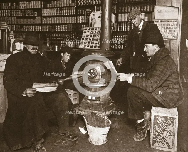A group of men around a stove in a shop, USA, c1910. Creator: Unknown.