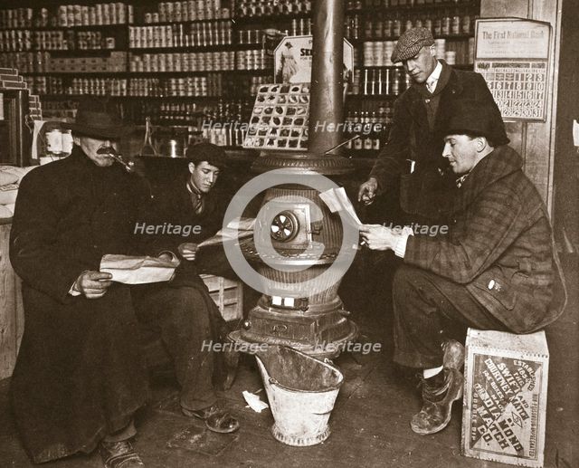 A group of men around a stove in a shop, USA, c1910. Creator: Unknown.