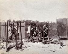 A group of men lower the body of a dead man on to a pyre of logs prior to a Hindu..., 1896/1897. Creator: Unknown