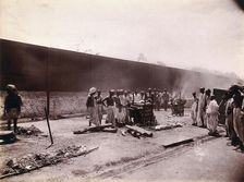 A group of men stand around the body of a man laid out on a pyre of logs during a Hindu..., 1896/97 Creator: Unknown