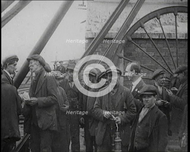 A Group of Miners Gathering and Smoking at a Pit Head, 1920. Creator: British Pathe Ltd.