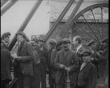 A Group of Miners Gathering and Smoking at a Pit Head, 1920. Creator: British Pathe Ltd
