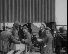 A Group of Miners Gathering and Smoking at a Pit Head, 1920. Creator: British Pathe Ltd
