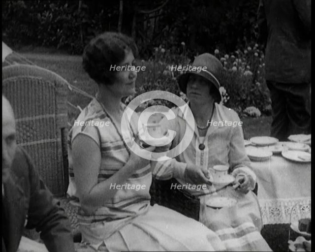A Group of People Drinking Tea and Eating Cakes in the Garden, 1926. Creator: British Pathe Ltd.