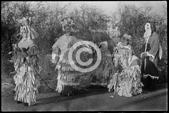 A group of people in costume performing in a Mummers' play, Andover, Test Valley, Hampshire, 1948. Creator: George R Long.