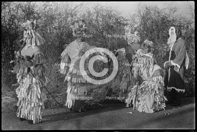 A group of people in costume performing in a Mummers' play, Andover, Test Valley, Hampshire, 1948. Creator: George R Long.