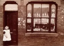A grocer's shop in England: doorway and shop window, (1900?). Creator: Unknown