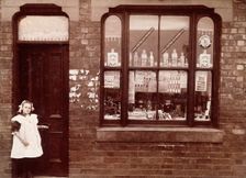 A grocer's shop in England: doorway and shop window, (1900?). Creator: Unknown