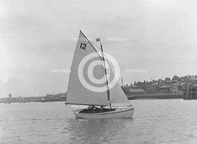 A Hamble River Class dinghy (No 12) sailing close-hauled, 1921. Creator: Kirk & Sons of Cowes.