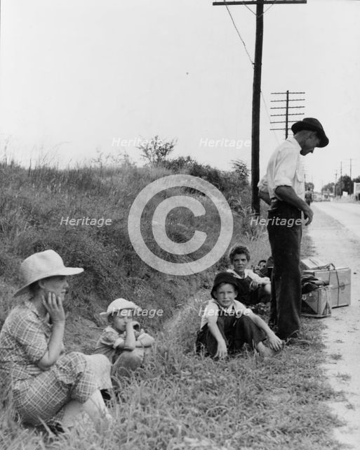 A hitchhiking family waiting along the highway in Macon, Georgia, 1937. Creator: Dorothea Lange.