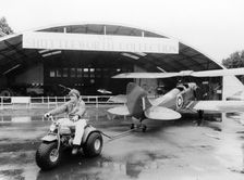 A Honda all terrain cycle pulling a vintage biplane, 1982