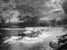 A Lancia Lambda being driven through water, c1925