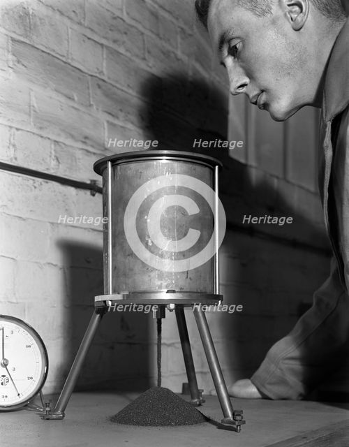 A lab technician undertaking a coal flow test, Mapperley Colliery, Derbyshire, 1962.  Creator: Michael Walters.