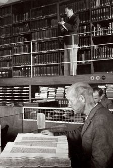 A labourer reads a book in a library, Germany, 1936. Creator: Unknown