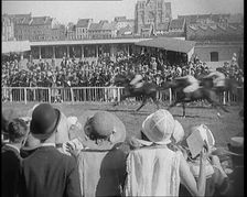 A Large Crowd of Civilians Wearing Smart Outfits and Hats Watching a Horse Race, 1920. Creator: British Pathe Ltd