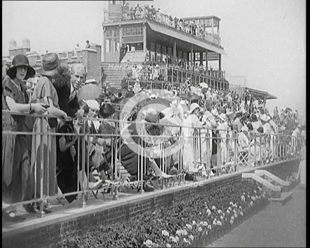 A Large Crowd of Civilians Wearing Smart Outfits and Hats Watching a Horse Race, 1920. Creator: British Pathe Ltd.