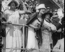 A Large Crowd of Civilians Wearing Smart Outfits and Hats Watching a Horse Race, 1920. Creator: British Pathe Ltd