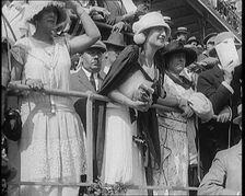 A Large Crowd of Civilians Wearing Smart Outfits and Hats Watching a Horse Race, 1920. Creator: British Pathe Ltd