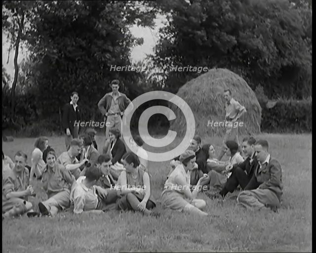 A Large Group of Hikers Having Drinks in a Field Beside a Haystack, 1931. Creator: British Pathe Ltd.