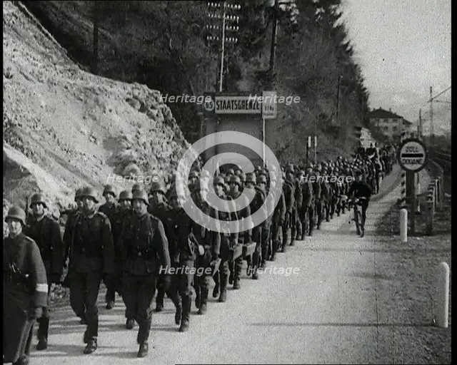 A Line of Male German Soldiers Marching Through a Customs Point Alongside a High Bank..., 1938. Creator: British Pathe Ltd.